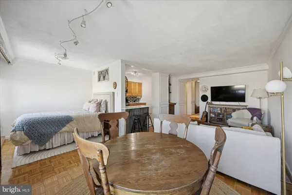 a living room with furniture a flat screen tv and a dining table