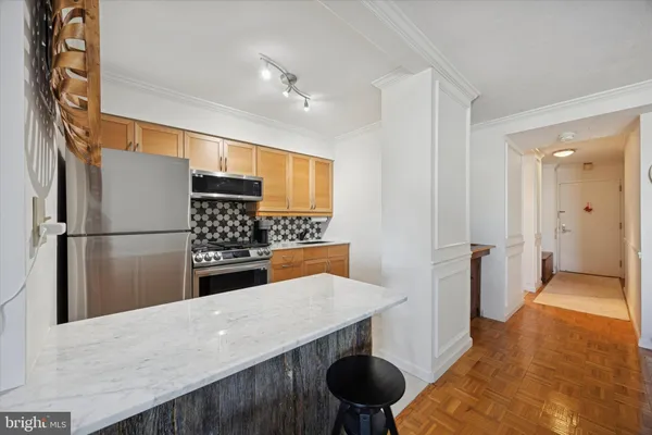 a kitchen with stainless steel appliances granite countertop a refrigerator a sink and a stove