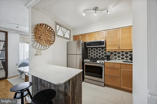 a kitchen with stainless steel appliances granite countertop a stove a refrigerator and a dining table with wooden floor