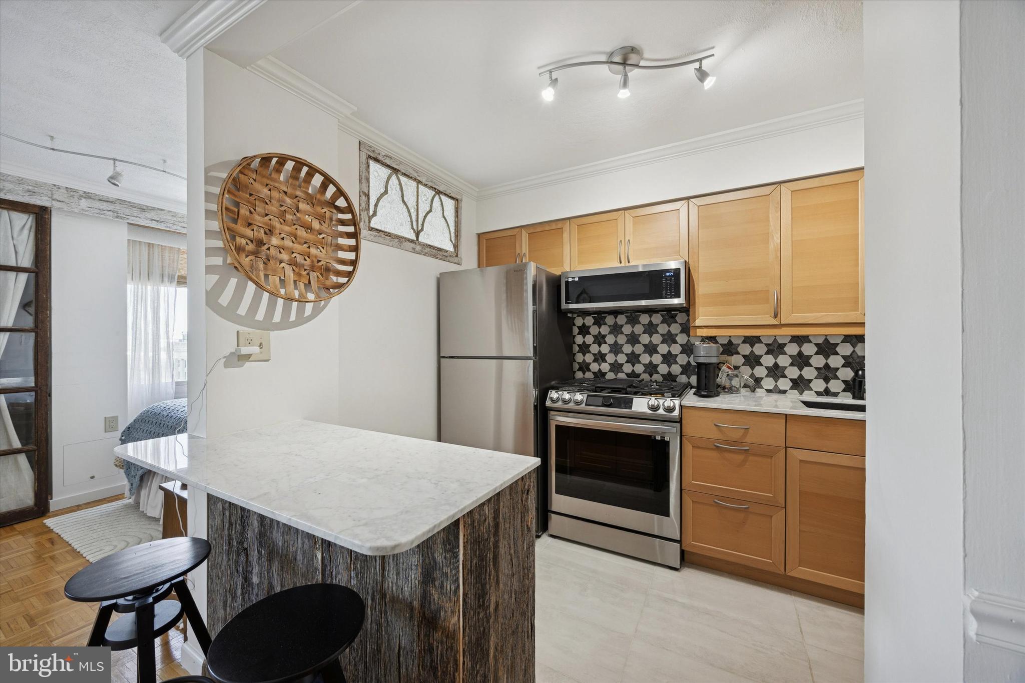 604 South Washington Square, Unit 1806 Philadelphia, PA 19106 - Photo 7 of 23 a kitchen with stainless steel appliances granite countertop a stove a refrigerator and a dining table with wooden floor