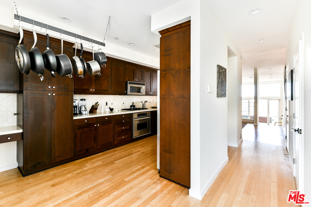 7301 Vista Del Mar, Unit 40 Playa del Rey, CA 90293 - Photo 12 of 29 a view of kitchen with stainless steel appliances kitchen island granite countertop a refrigerator and a wooden floor