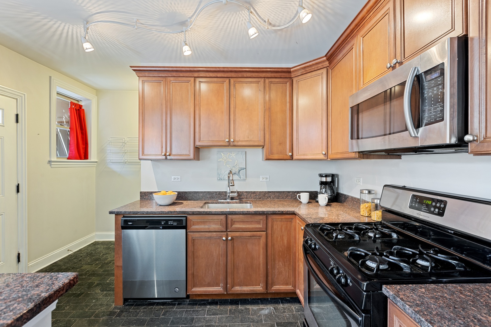 1905 West Winona Street, Unit 2 Chicago, IL 60640 - Photo 9 of 18 a kitchen with stainless steel appliances granite countertop a stove a sink dishwasher and cabinets with wooden floor