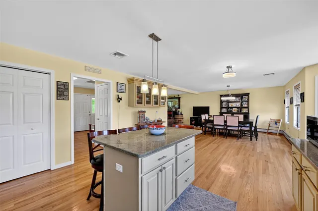a kitchen that has a table chairs and wooden floor