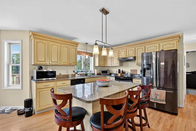 a kitchen with refrigerator a stove and chairs