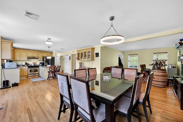 a view of a dining room and livingroom with furniture wooden floor a chandelier