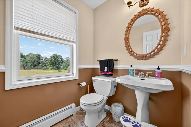 a bathroom with a toilet sink mirror and vanity