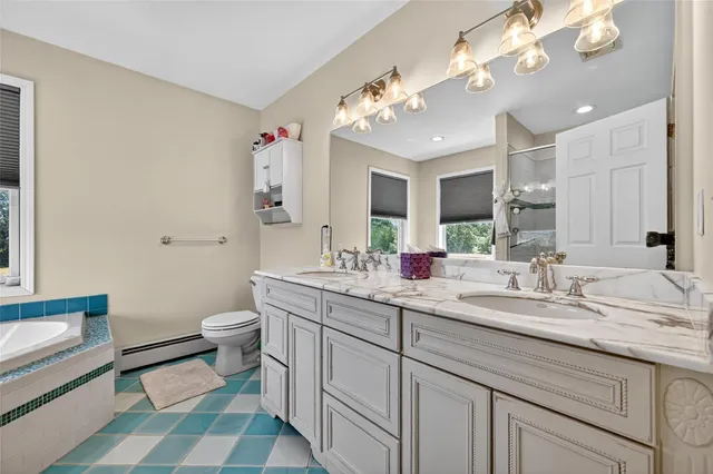 a bathroom with a tub sink and mirror