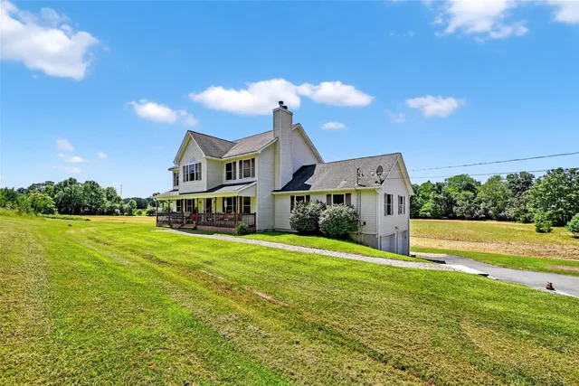 a front view of house with yard and ocean