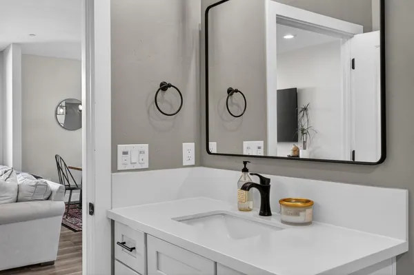 a kitchen with stainless steel appliances kitchen island granite countertop wooden floors and white cabinets