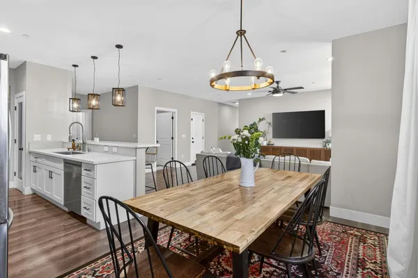 a kitchen with stainless steel appliances granite countertop a refrigerator a stove top oven a sink dishwasher and a refrigerator with wooden floor