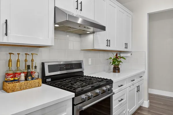 a kitchen with stainless steel appliances a sink stove and cabinets