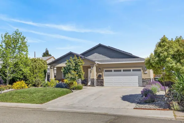 a front view of a house with a garden and plants