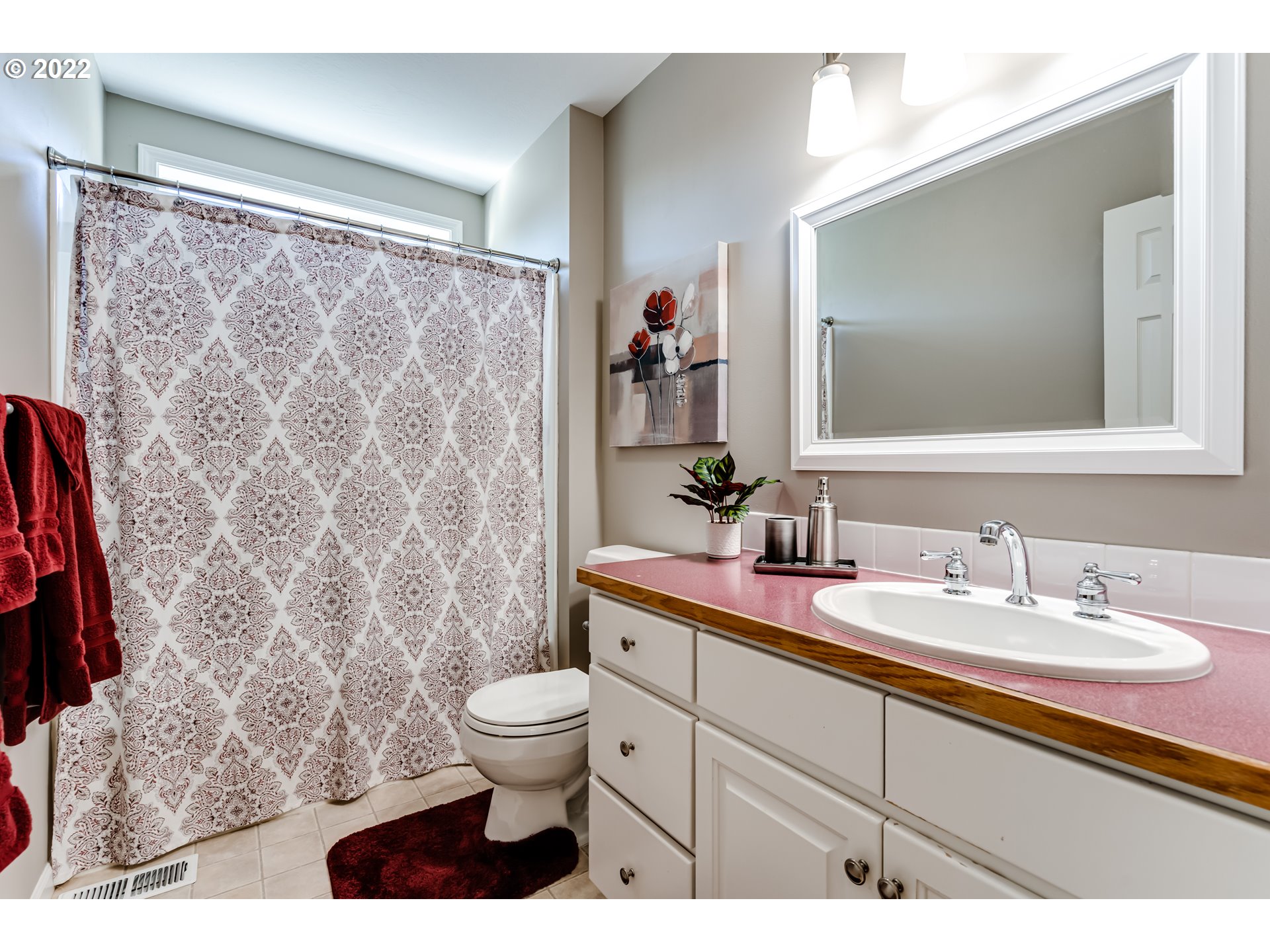 3987 Brae Burn Drive Eugene, OR 97405 - Photo 19 of 32 a bathroom with a granite countertop sink a toilet a mirror and shower curtain