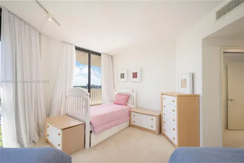 a bedroom with furniture and a large window