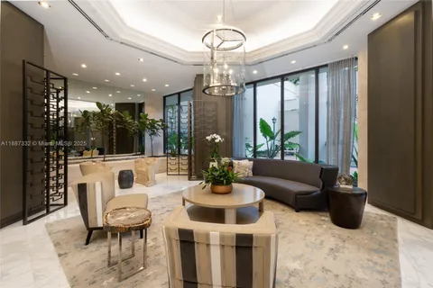 a living room with furniture a chandelier and a view of kitchen