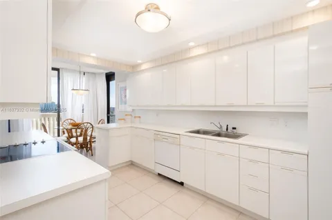 a kitchen with white cabinets and sink