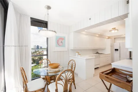 a kitchen with stainless steel appliances a dining table chairs and sink