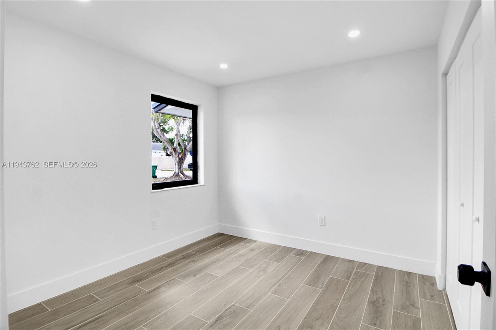 13379 Northwest 3rd Terrace Miami, FL 33182 - Photo 15 of 23 an empty room with wooden floor and window