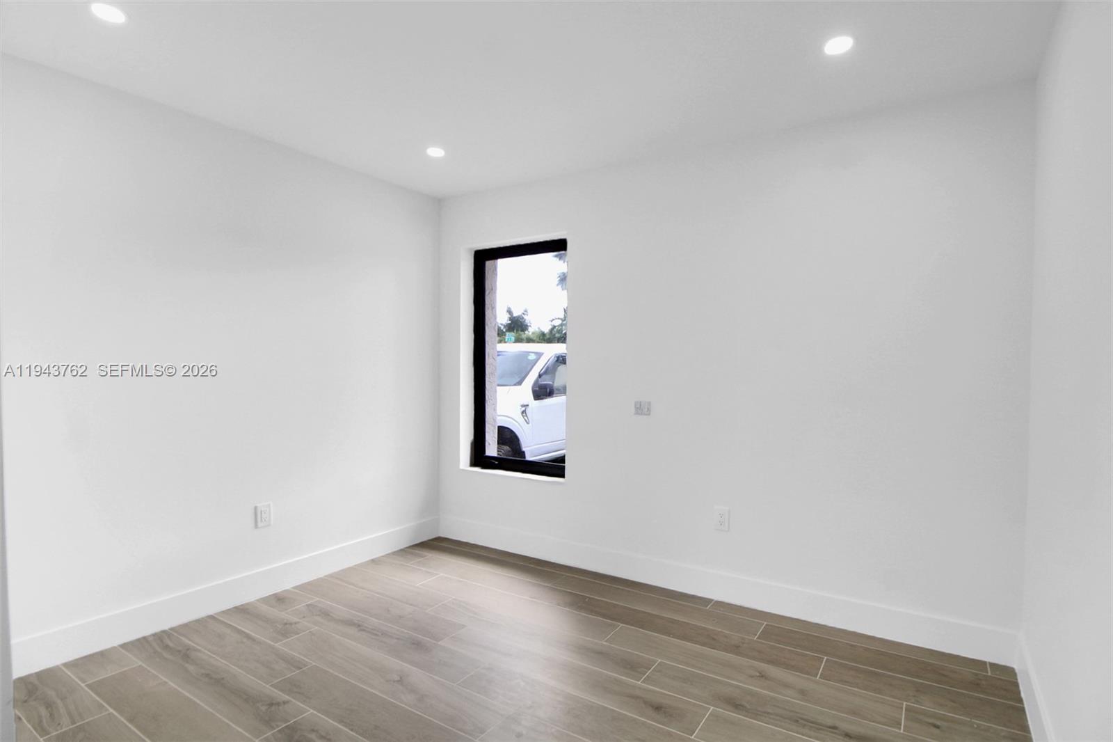 13379 Northwest 3rd Terrace Miami, FL 33182 - Photo 18 of 23 an empty room with wooden floor and windows
