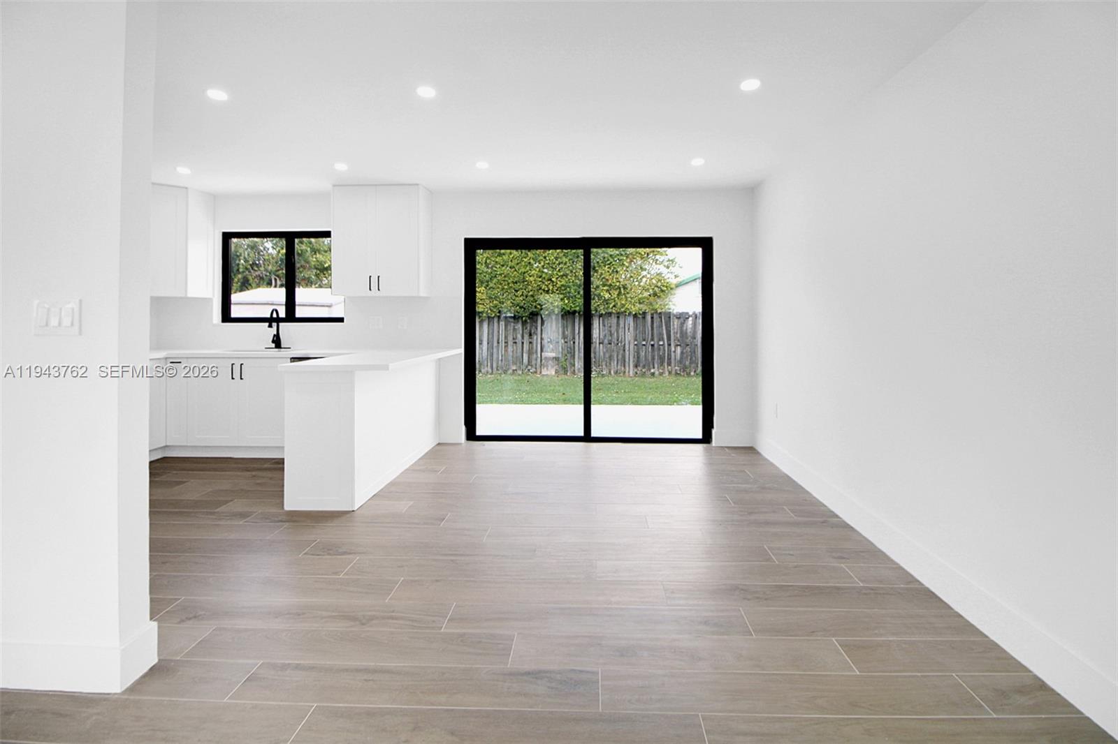 13379 Northwest 3rd Terrace Miami, FL 33182 - Photo 5 of 23 an empty room with wooden floor and windows