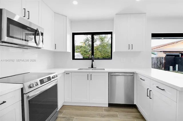 a kitchen with stainless steel appliances white cabinets and a sink