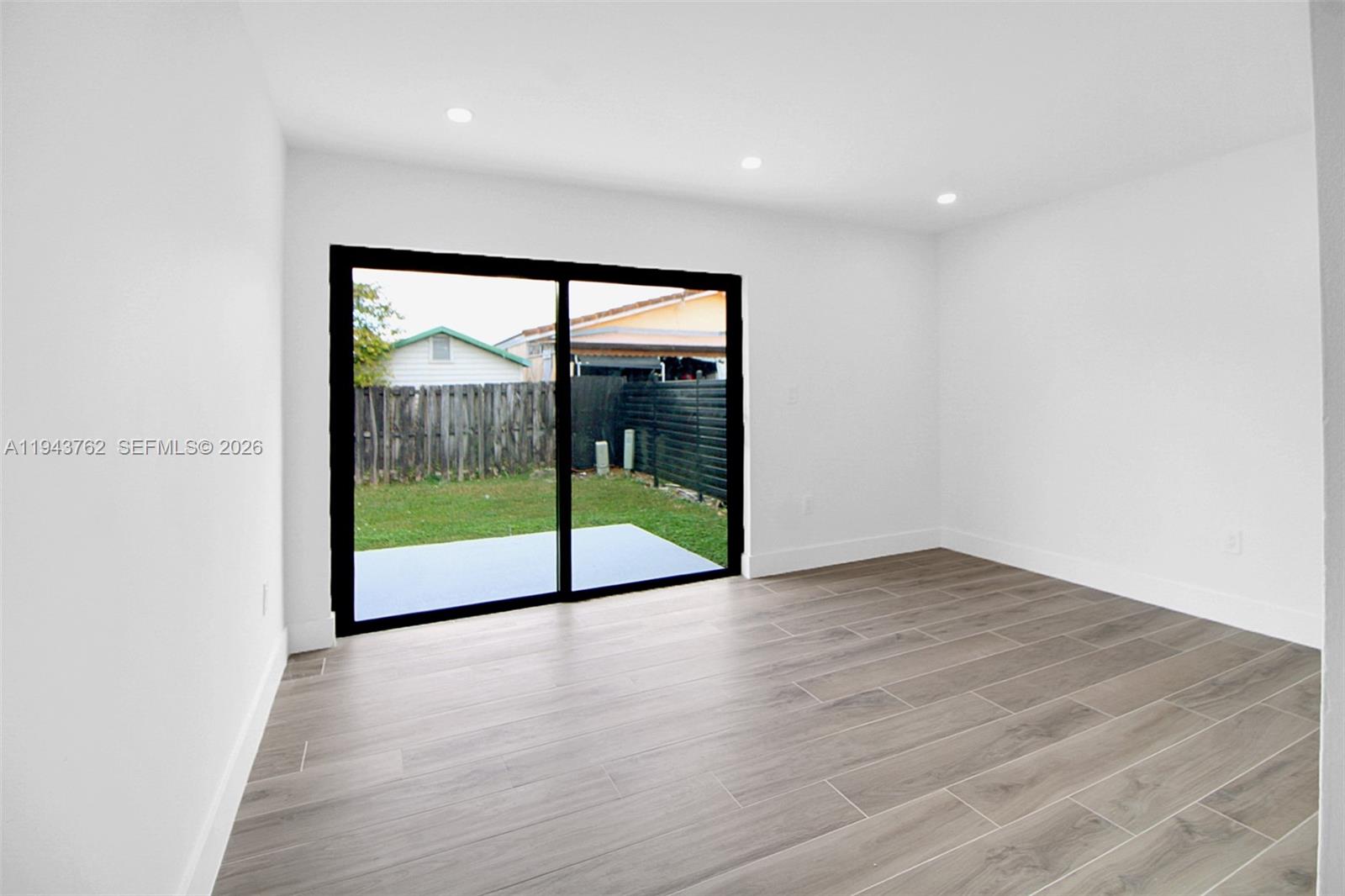 13379 Northwest 3rd Terrace Miami, FL 33182 - Photo 10 of 23 a view of an empty room with wooden floor and a window