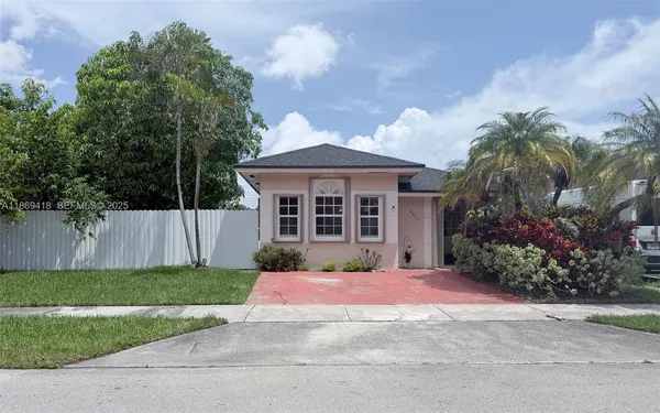 a front view of a house with a yard and potted plants