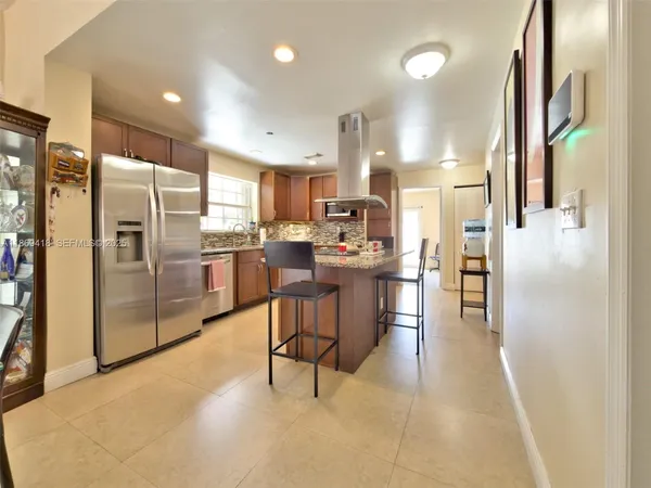 a kitchen with stainless steel appliances a refrigerator and a stove top oven