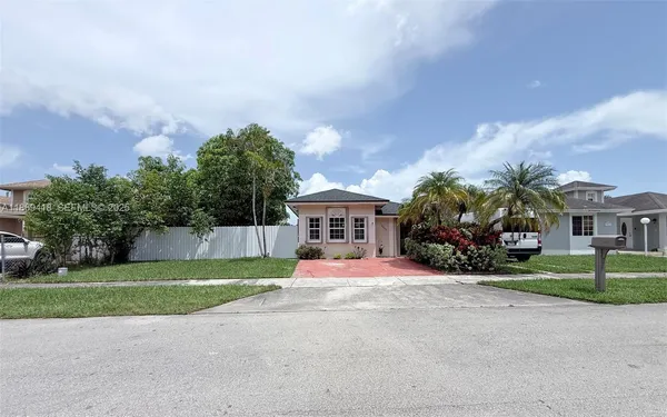 a view of a house with a yard and large trees