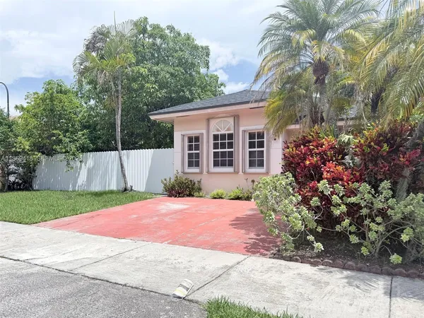 a view of a house with a yard and potted plants