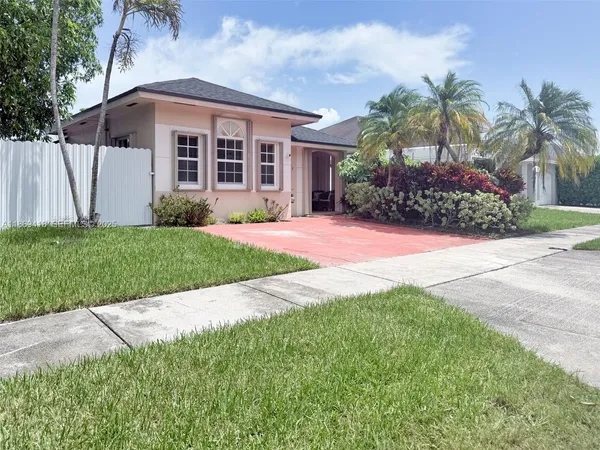 a front view of a house with a garden and yard