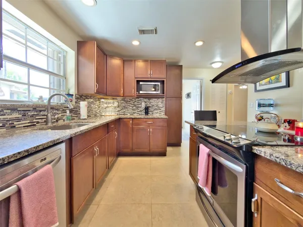 a kitchen with stainless steel appliances granite countertop a sink stove and cabinets