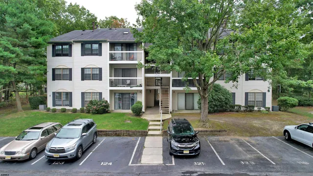 a front view of a house with a garden and trees