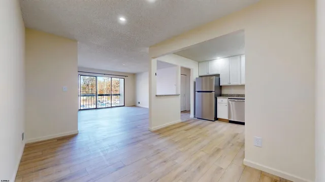 a view of a kitchen with stainless steel appliances a refrigerator and wooden floor