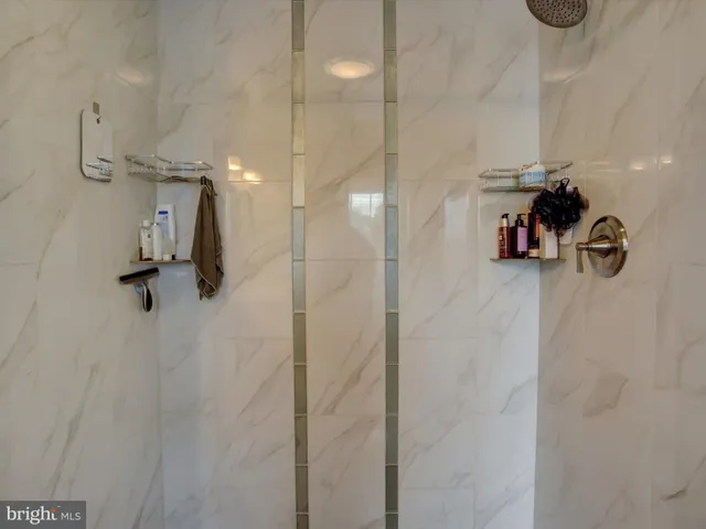a bathroom with a bathtub shower sink mirror and toilet