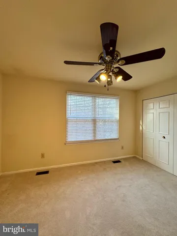 a view of a room with window and a ceiling fan