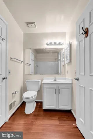 a bathroom with a toilet sink a mirror and vanity
