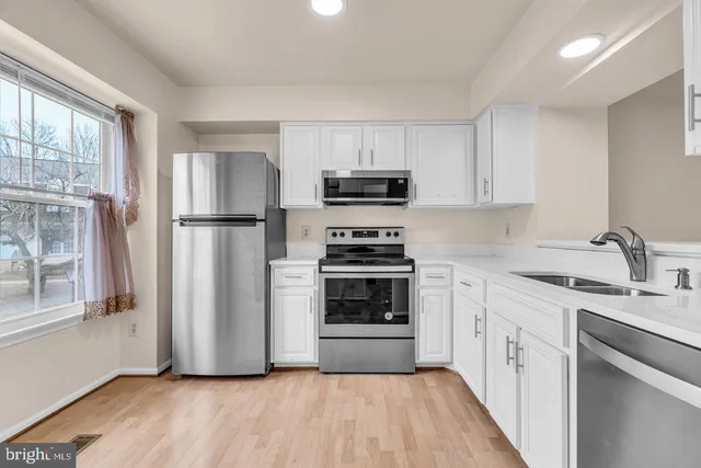 a kitchen with a refrigerator a stove a sink and a window