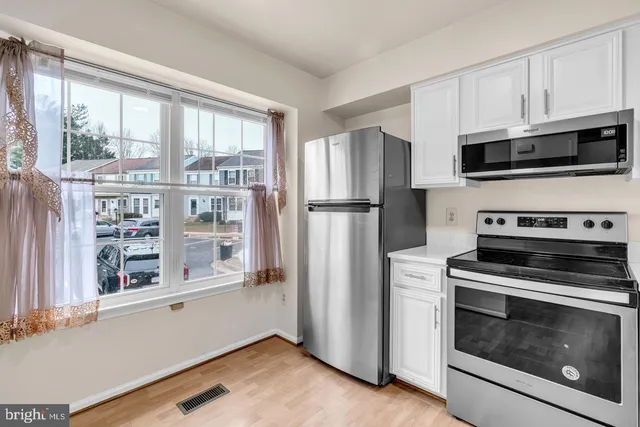 a kitchen with stainless steel appliances a stove a microwave and a refrigerator