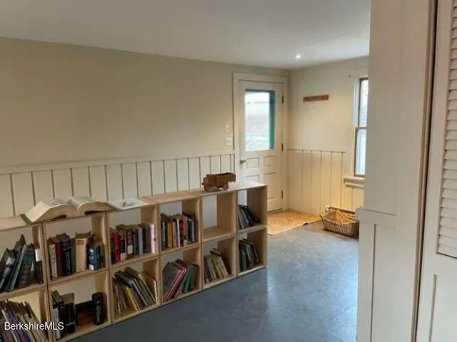 a view of a workspace with furniture and a book shelf