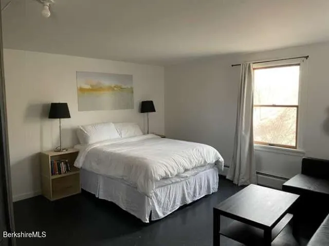 a bedroom with a bed and windows