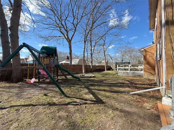 a view of yard with wooden deck and furniture
