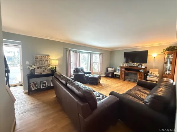 a living room with furniture and a flat screen tv with kitchen view