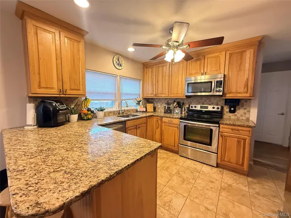 a kitchen with stainless steel appliances granite countertop a sink a stove and cabinets