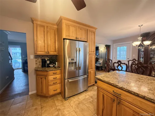 a kitchen with stainless steel appliances granite countertop a refrigerator a stove and a sink