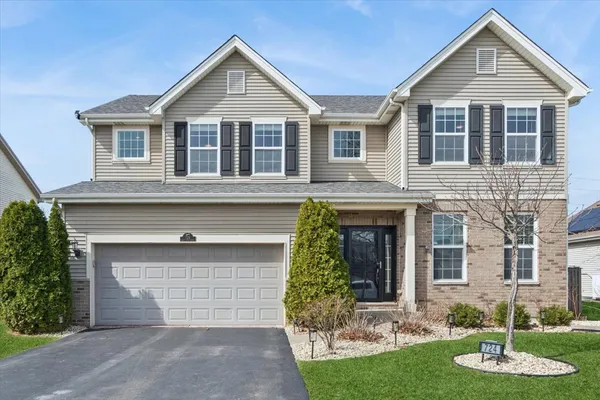 a front view of a house with a yard and garage