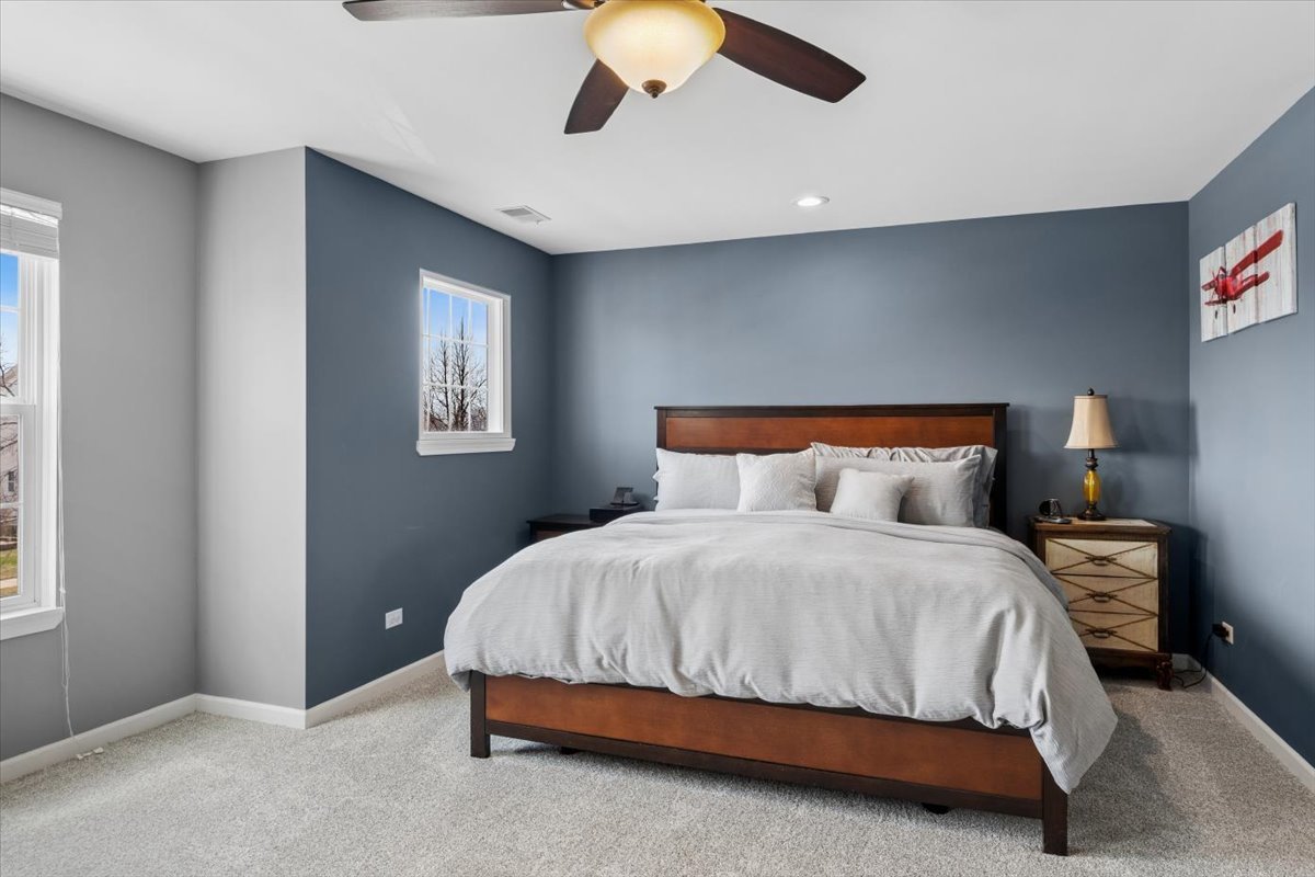 724 North Misty Ridge Drive Romeoville, IL 60446 - Photo 11 of 26 a bedroom with a bed and a lamp