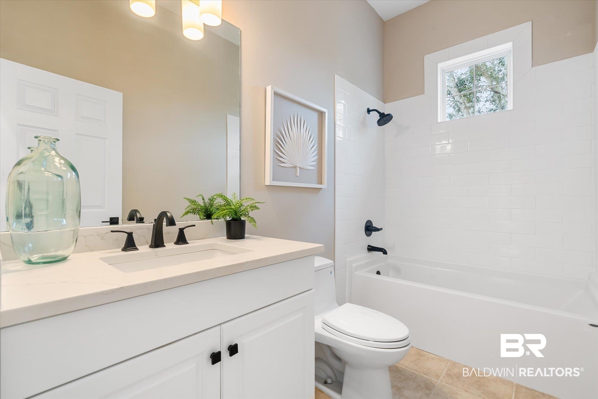 9259 Genipa Way Gulf Shores, AL 36542 - Photo 32 of 72 Full bathroom with vanity, tiled shower / bath combo, tile patterned floors, and toilet