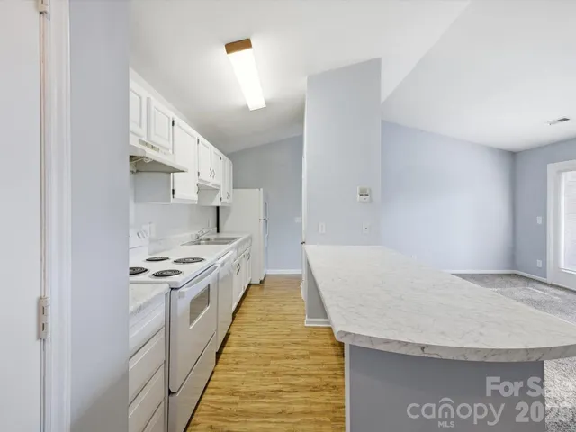 a kitchen with kitchen island white cabinets and stainless steel appliances