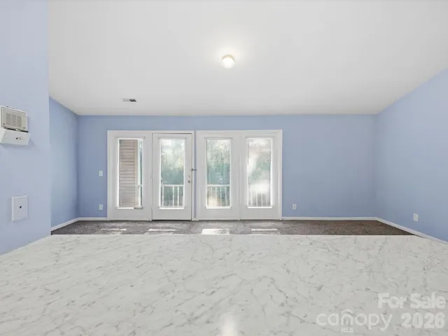 a view of a hallway with wooden floor and a bathroom